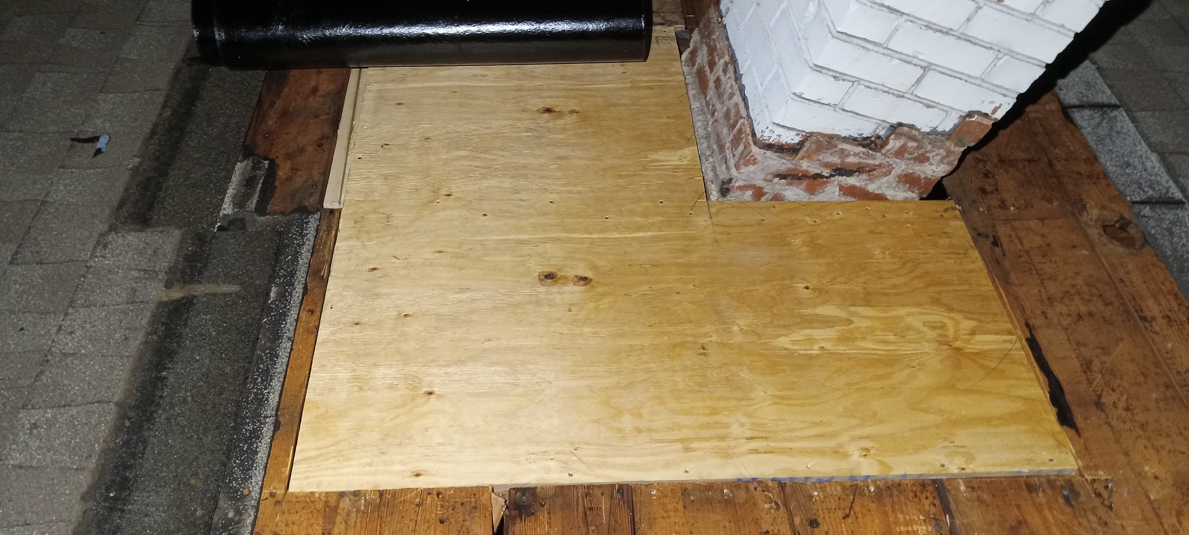 New plywood roof sheathing fitted around a masonry chimney