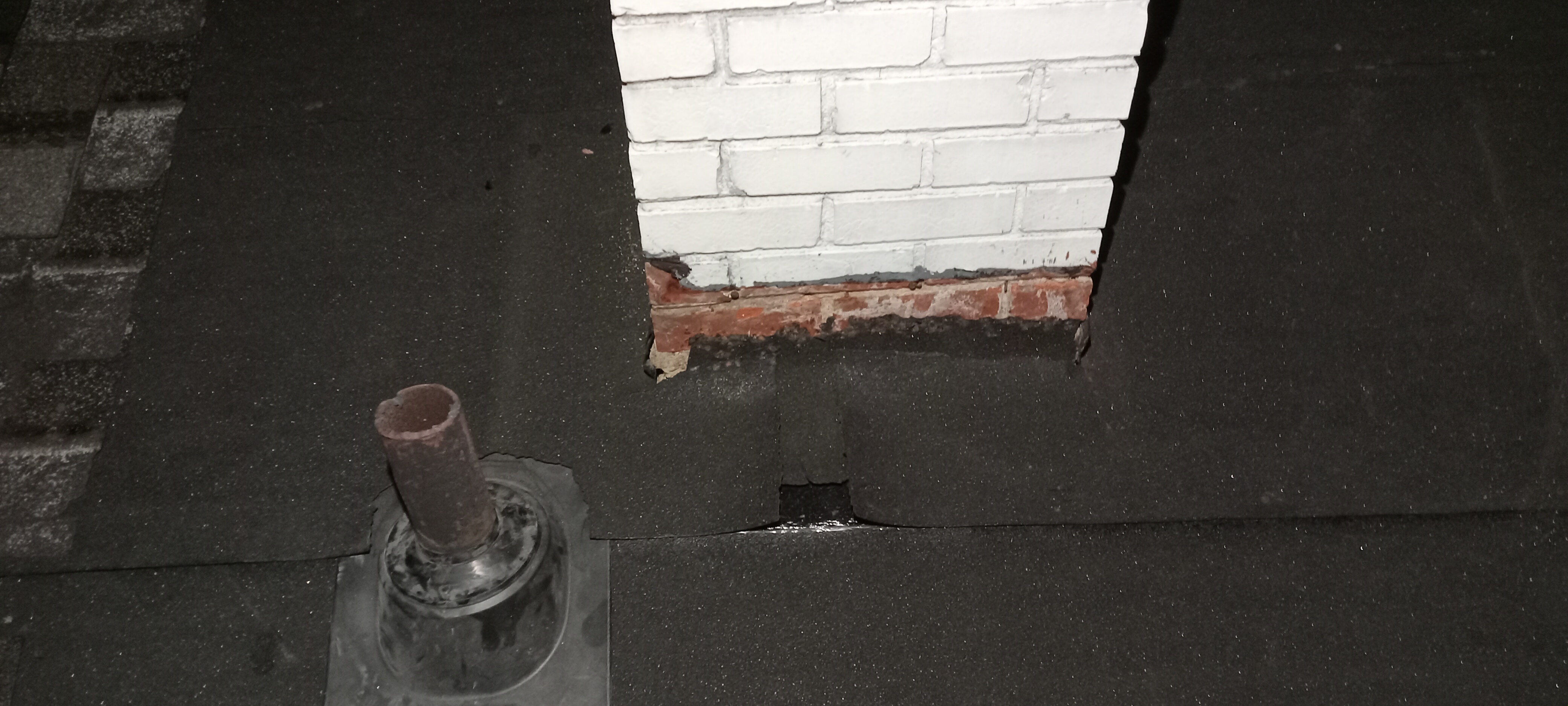 Water-resistant membrane installed around a chimney repair area before roof covering restoration